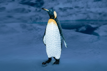 LED-illuminated acrylic Daddy Penguin figurine standing on a snowy blue base. A whimsical outdoor Christmas sculpture, perfect for winter wonderland displays.